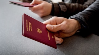 Mann hält einen Reisepass in der Hand